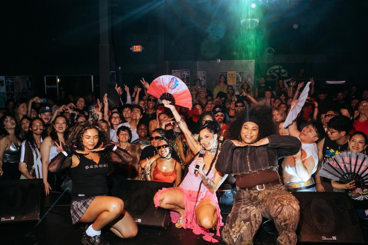 Dina Ben-Nissan, La Goony Chonga, and Courtney Hollinquest pose onstage while attending Baile.