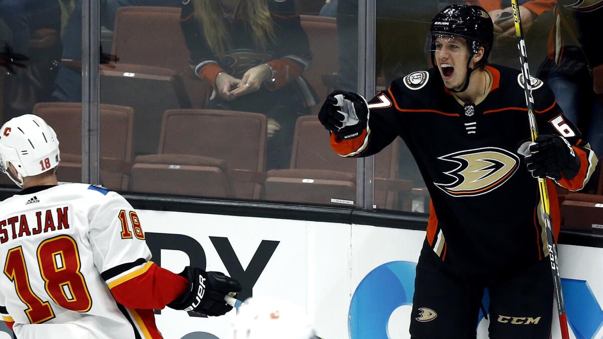 Ducks center Rickard Rakell after scoring during the third period against center Matt Stajan and the Flames on Friday night.