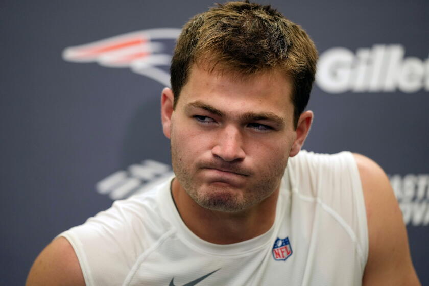 New England Patriots quarterback Drake Maye closes his mouth tightly during a press conference