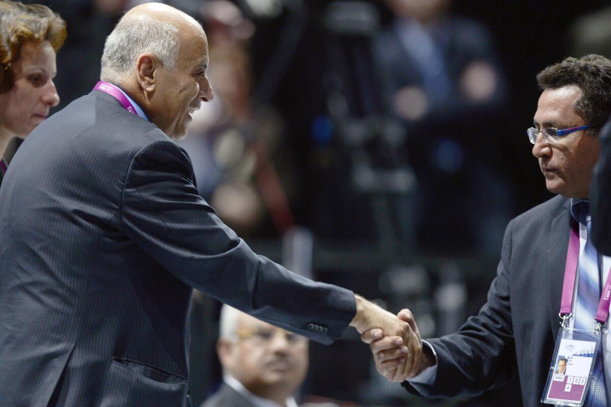 Palestinian Football Assn. President Jibril Rajoub, left, and Israeli Football Assn. chief Ofer Eini, shake hands after a contentious debate Friday over soccer events in disputed territory during the 65th FIFA Congress in Zurich, Switzerland.