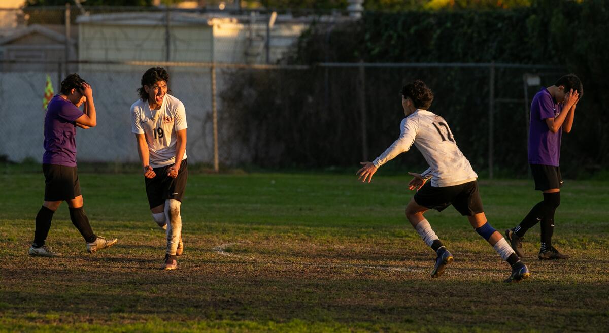 Los Amigos' Oracio Teriquez, right, celebrates with Erubey Bermudez after he scores the winning goal in overtime.