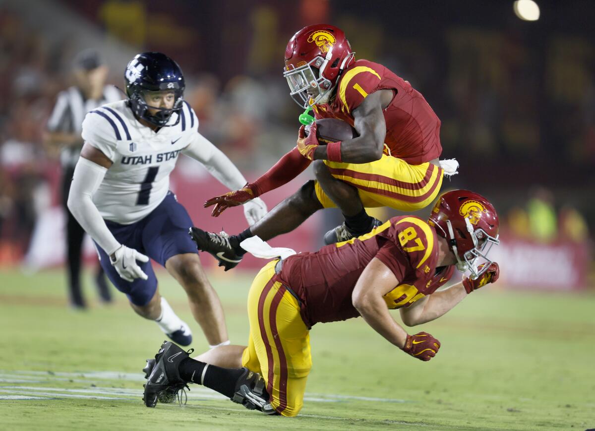 USC wide receiver Zachariah Branch leaps over tight end Lake McRee.