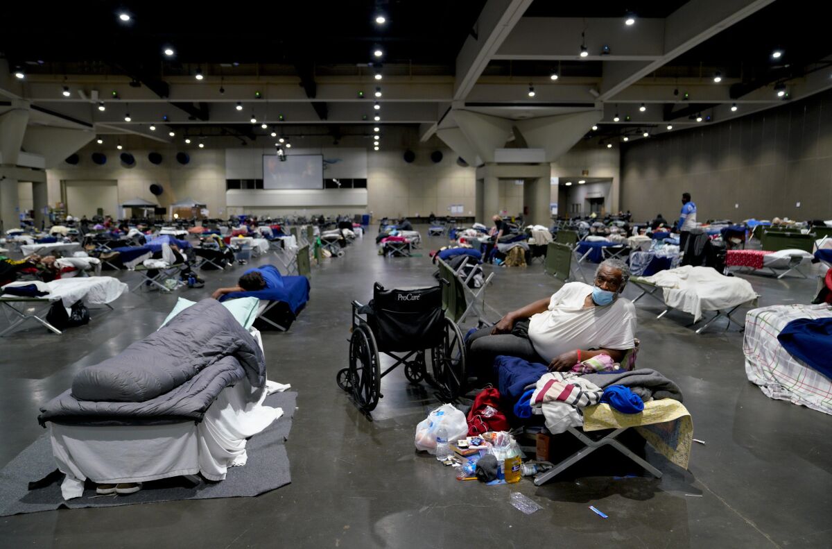  James Sneed, relaxing on his cot, has been staying at the homeless shelter inside the San Diego Convention Center.
