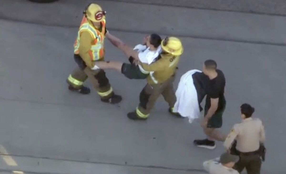 Firefighters carry an injured sheriff's cadet