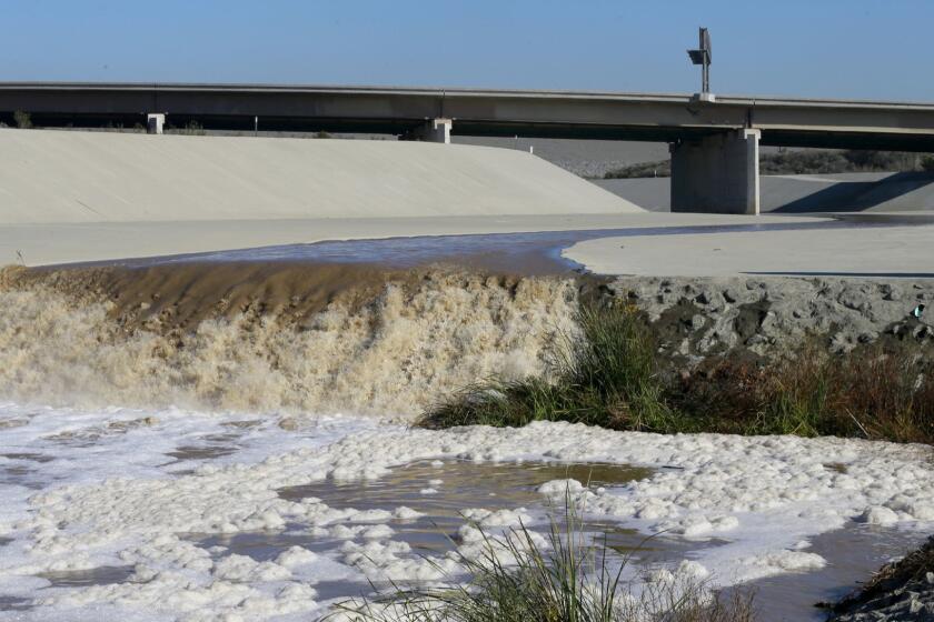 CORONA, CALIF. -- FRIDAY, JANUARY 8, 2016: Storm water flows down the Santa Ana River channel from Prado Dam while hydrologic technicians with the USGS California Water Science Center, conducting high-flow velocity and volume measurements in Corona, Calif., on Jan. 8, 2016. U.S. Geological Survey stream flow gauges are recording major and minor flooding on streams and rivers throughout California as a result of several El Niño storms bringing rain and snow to the region. (Allen J. Schaben / Los Angeles Times)