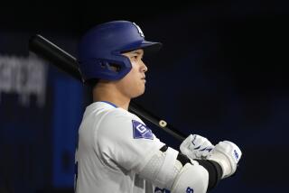 Los Angeles Dodgers designated hitter Shohei Ohtani stands in the dugout as he gets set to bat during the first inning of a baseball game against the San Diego Padres at the Gocheok Sky Dome in Seoul, South Korea Thursday, March 21, 2024, in Seoul, South Korea. (AP Photo/Lee Jin-man)