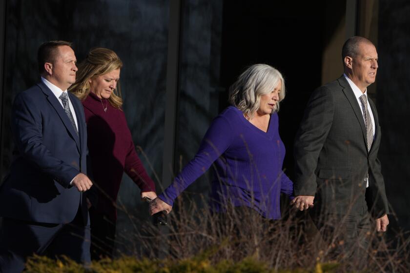 Paramedics Jeremy Cooper, far left, and Peter Cichuniec, far right, enter the Adams County, Colo., Justice Center, Friday, Dec. 22, 2023, in Brighton, Colo. A Colorado prosecutor says the two paramedics failed to properly care for Elijah McClain when they overdosed the Black man with a sedative that he didn’t need. McClain, a 23-year-old massage therapist, died after being stopped and forcibly restrained by police officers and then injected with ketamine in 2019 in the Denver suburb of Aurora. (AP Photo/David Zalubowski)