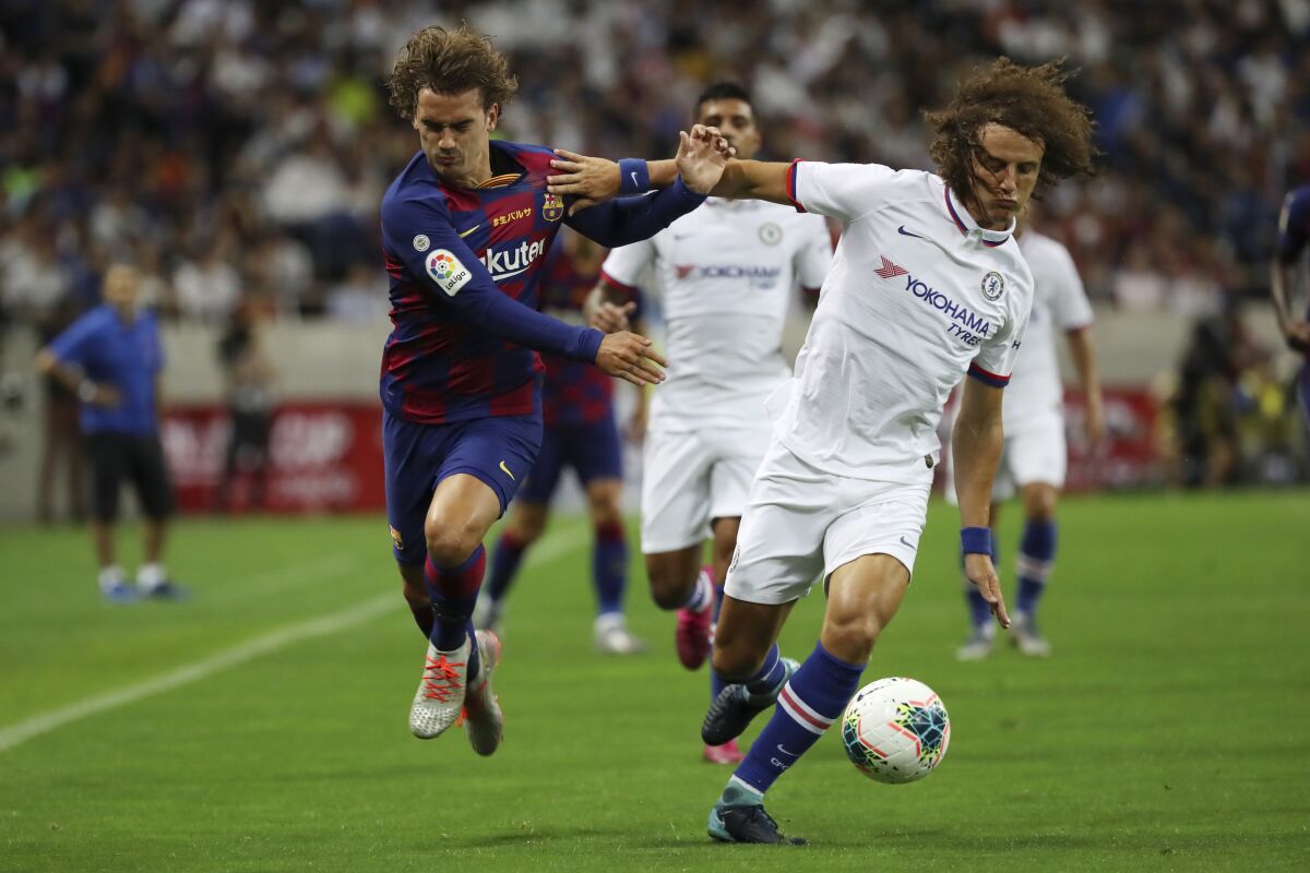 El defensor de Chelsea David Luiz, derecha, y el atacante de Barcelona Antoine Griezmann se disputan el balón en un partido de exhibición en Saitama, al norte de Tokio, el 23 de julio del 2019.