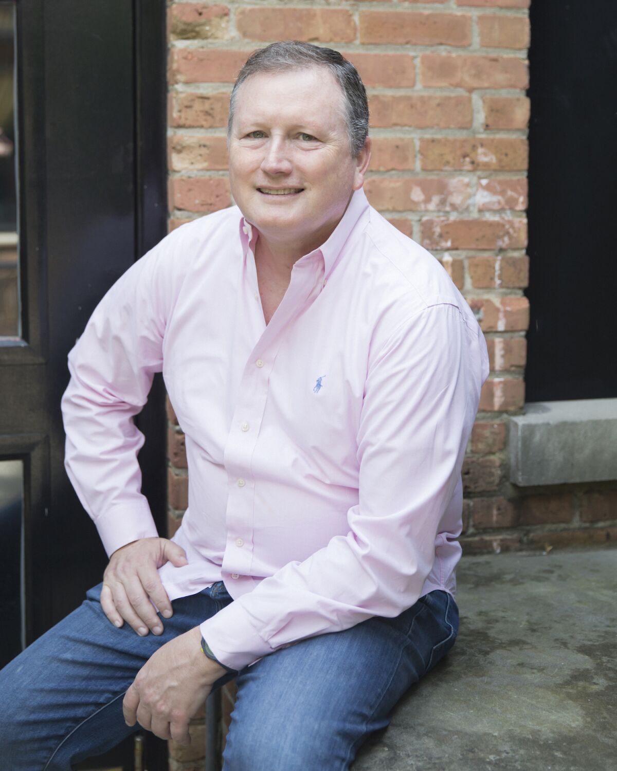 A headshot of a man in a button-down shirt