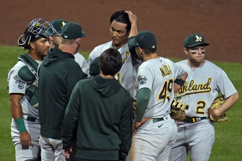 CORRECTS TO RELIEF PITCHER NOT STARTING PITCHER - Oakland Athletics relief pitcher Shintaro Fujinami, center top, gets a visit from pitching coach Scott Emerson second from left, during the sixth inning of a baseball game against the Pittsburgh Pirates in Pittsburgh, Monday, June 5, 2023. (AP Photo/Gene J. Puskar)