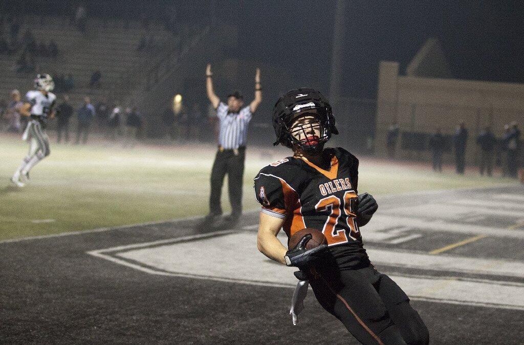 Huntington Beach's Travis Heer scores a touchdown during a game against Newport Harbor on Friday.