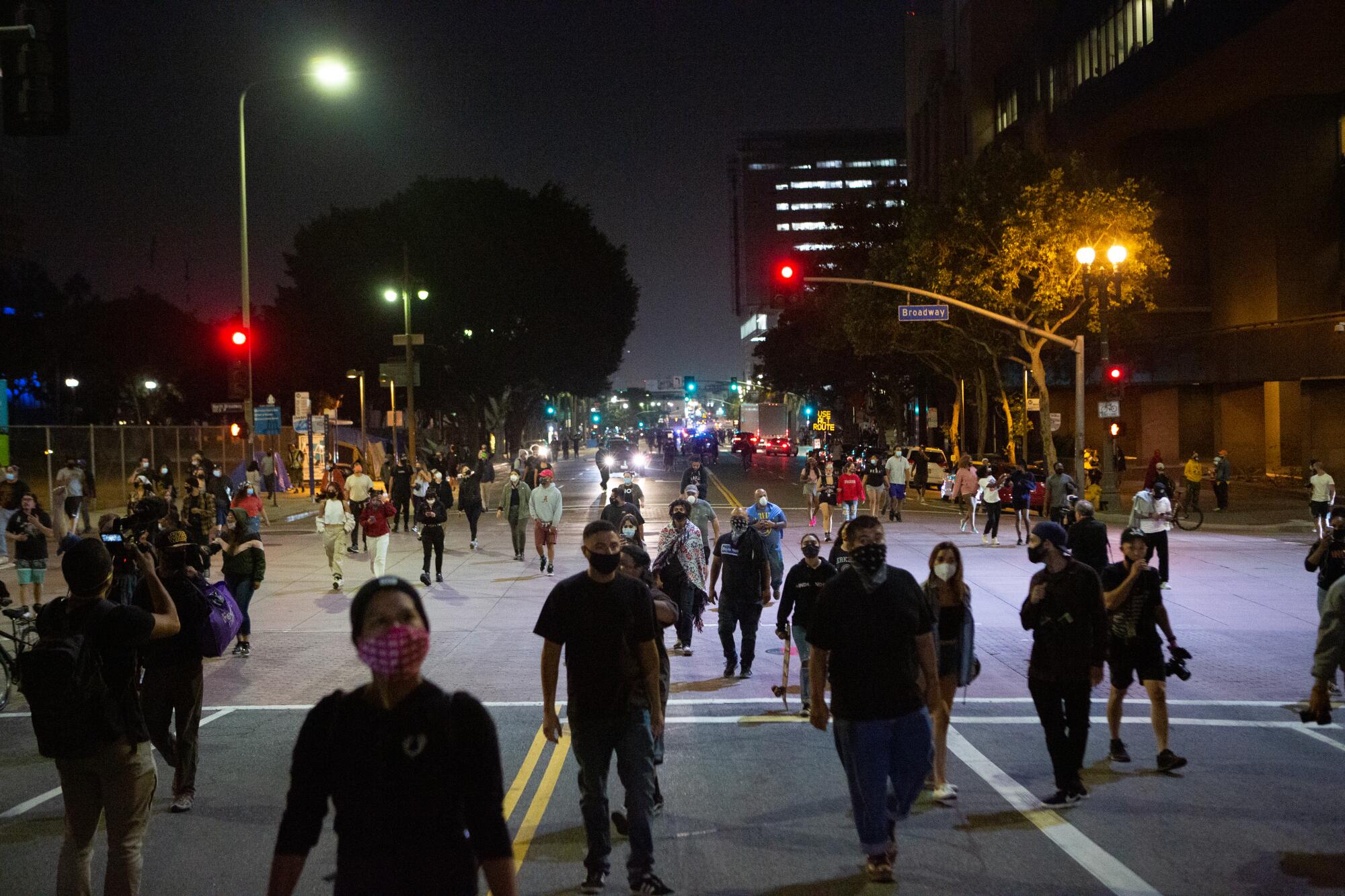 Protesters cross Broadway heading up toward Hill Street in downtown Los Angeles 