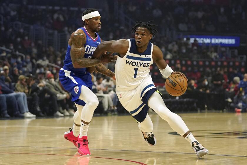 Minnesota Timberwolves forward Anthony Edwards, right, drives toward the basket as Los Angeles Clippers guard Eric Bledsoe defends during the first half of an NBA basketball game Monday, Jan. 3, 2022, in Los Angeles. (AP Photo/Mark J. Terrill)
