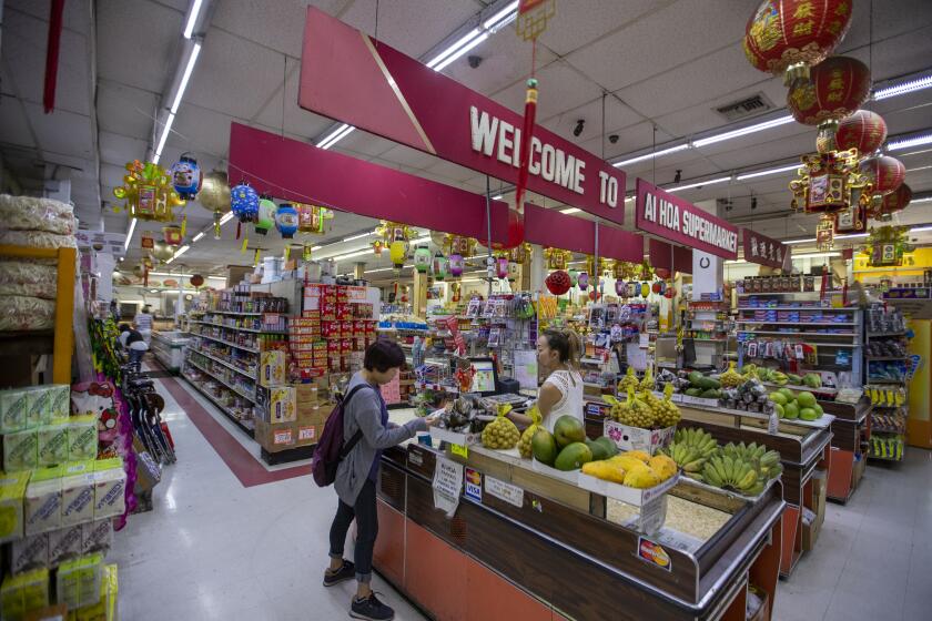 LOS ANGELES, CALIF. -- FRIDAY, SEPTEMBER 20, 2019: A customer purchases groceries at Ai Hoa Market in Chinatown in Los Angeles, Calif., on Sept. 20, 2019. Chinatown's grocery stores are dying out. Ai Hoa Market is slated to close at the end of the year. G and G Market has been evicted and will vacate their location at the end of the month. That means there will be no more full service grocery stores in Chinatown. There is one more vegetable store, Yue Wa market, but they do not sell meat and they are much smaller, and struggling as well. Many seniors also buy vegetables from vendors who drive by in the morning, and then spread tarps on the sidewalk to sell a few fruits and vegetables as well. (Allen J. Schaben / Los Angeles Times)