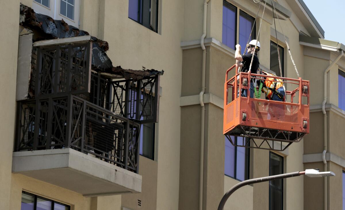 Workers examine a balcony that collapsed at an apartment building in Berkeley.
