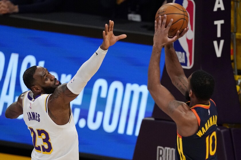 Golden State Warriors guard Brad Wanamaker, right, shoots as Los Angeles Lakers forward LeBron James defends during the first half of an NBA basketball game Sunday, Feb. 28, 2021, in Los Angeles. (AP Photo/Mark J. Terrill)