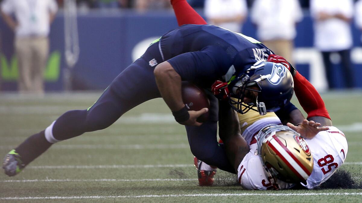 Seahawks quarterback Russell Wilson is sacked, and injured, by 49ers linebacker Eli Harold in the second half Sunday.