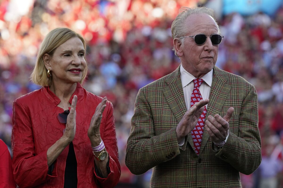 Olivia Manning and Archie Manning applaud as son Eli's number is retired by Ole Miss.