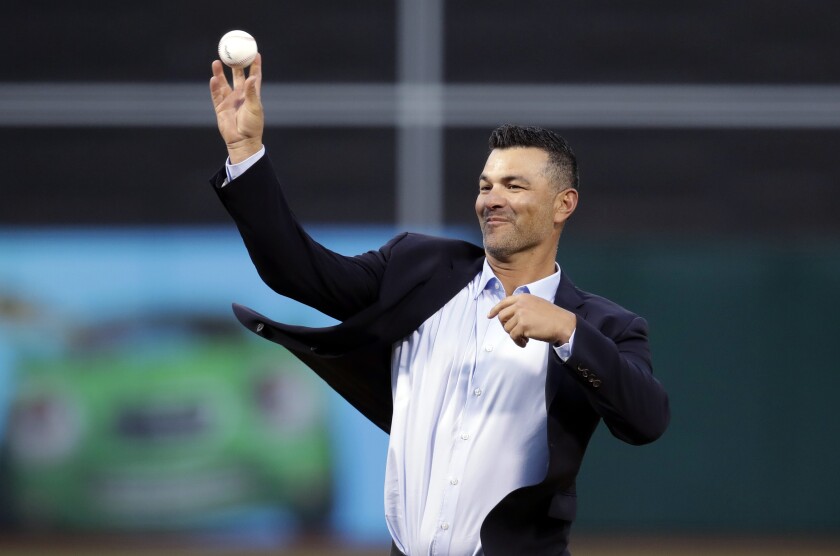 FILE - Former Oakland Athletic third baseman Eric Chavez throws out a ceremonial first pitch prior to the team's baseball game against the Los Angeles Angels, March 29, 2019, in Oakland, Calif. The New York Mets are set to hire Chavez as hitting coach, luring him away from their crosstown rivals as the team begins to put together a staff under new manager Buck Showalter. Chavez and the Mets have an agreement in place, according to a person familiar with the decision. The person spoke Thursday night, Jan. 6, on the condition of anonymity because the move had not been announced. (AP Photo/Ben Margot, File)
