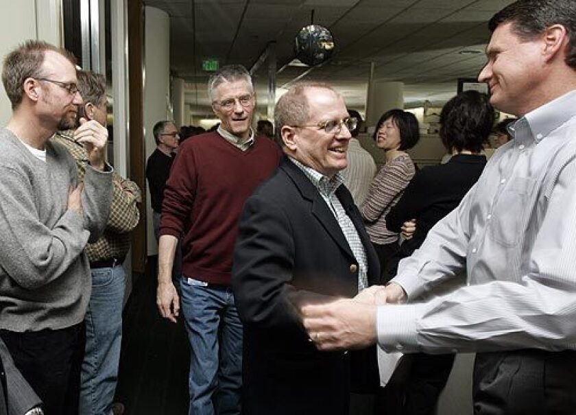 Los Angeles Times Editor James O'Shea, second from right, shakes hands with Jack Klunder, senior vice president of circulation, after making a farewell speech to newsroom staff.