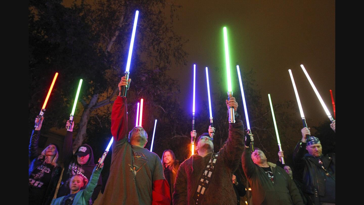 Star Wars fans raise their lightsabers in tribute to actress Carrie Fisher at the California Center for the Arts in Escondido on Friday.