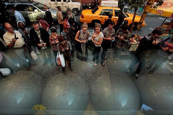 People look at the tributes to Steve Jobs outside the Apple store in New York City's SoHo neighborhood.