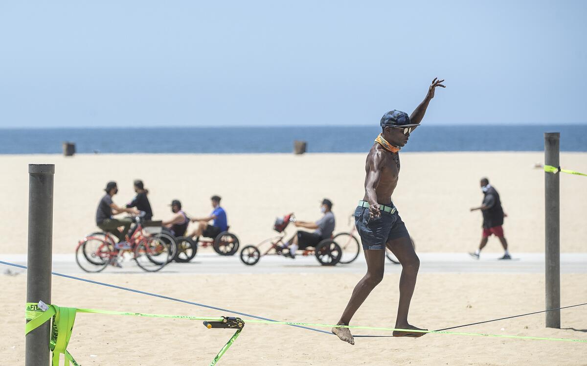 Jacob Laiser, 38, of Venice balances on a slack line while working out at Santa Monica Beach on Monday. 
