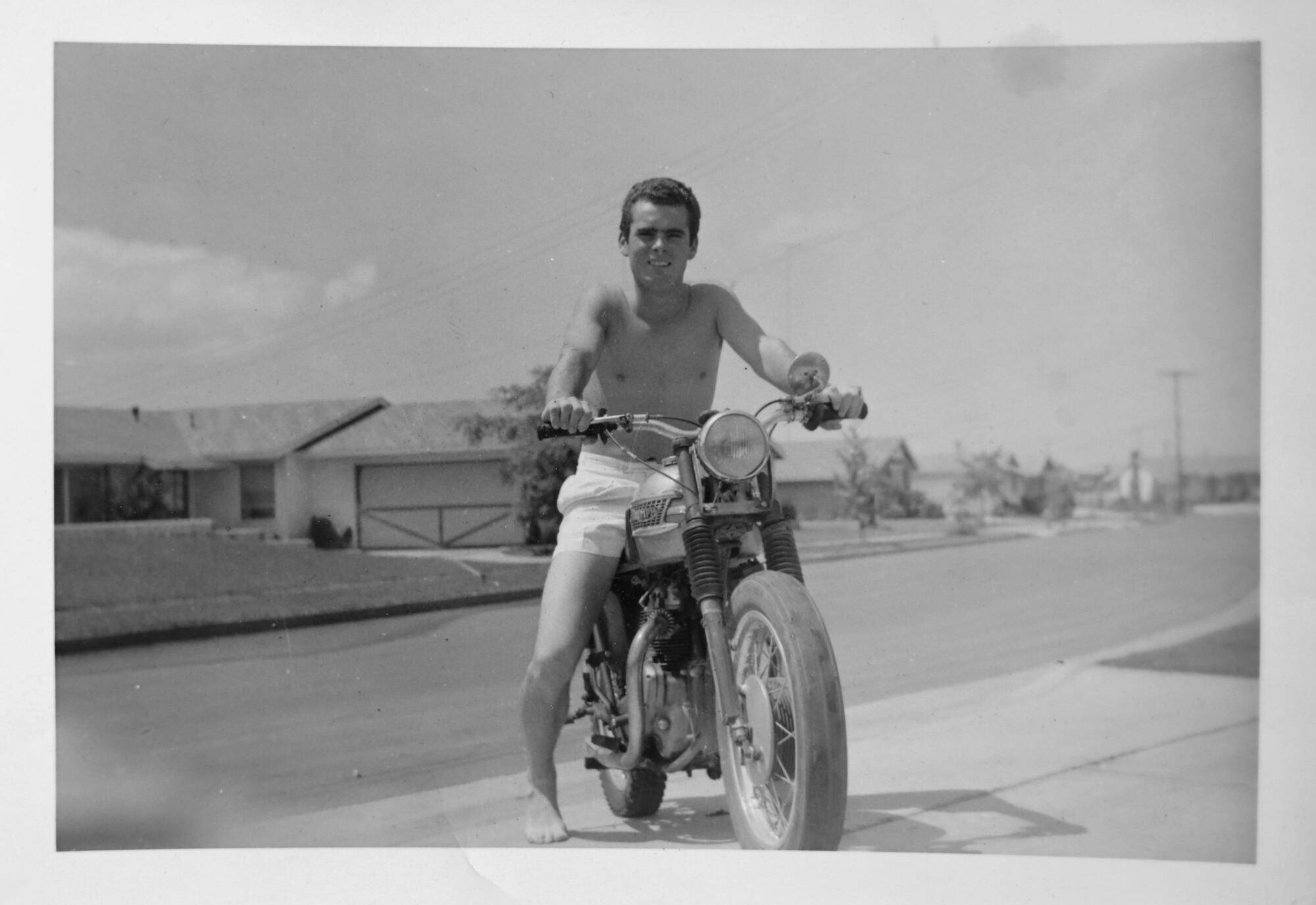 Black and white photo of a young man on a motorcycle