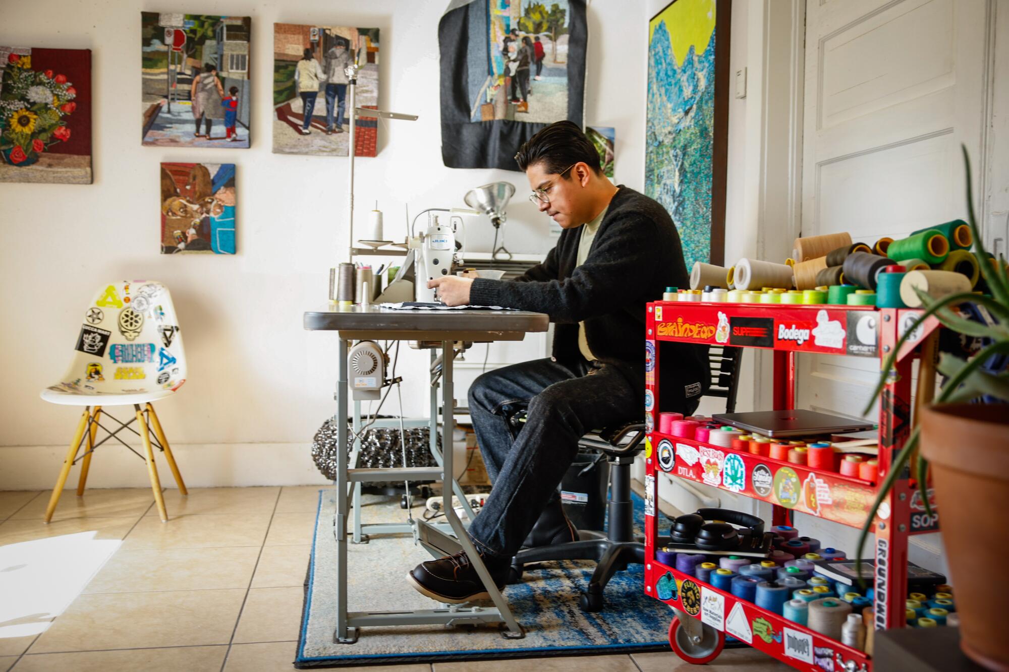 Artist Erick Medel works on one of his textile art pieces 