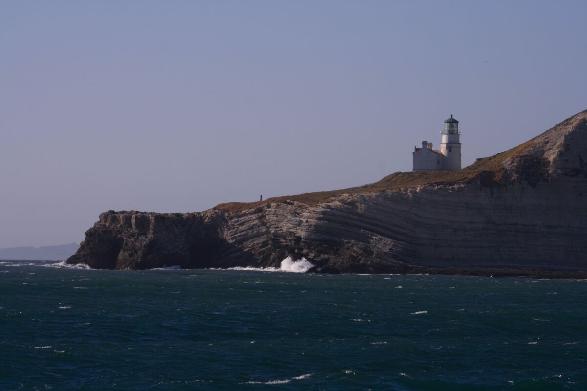 A lighthouse on a ocean cliff.