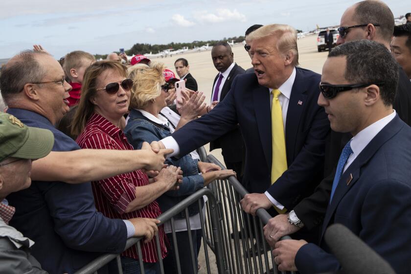 President Donald Trump shakes hands with supporters upon arrival at the Orlando Sanford International Airport, Monday, March 9, 2020 in Orlando, Fla. (AP Photo/Alex Brandon)