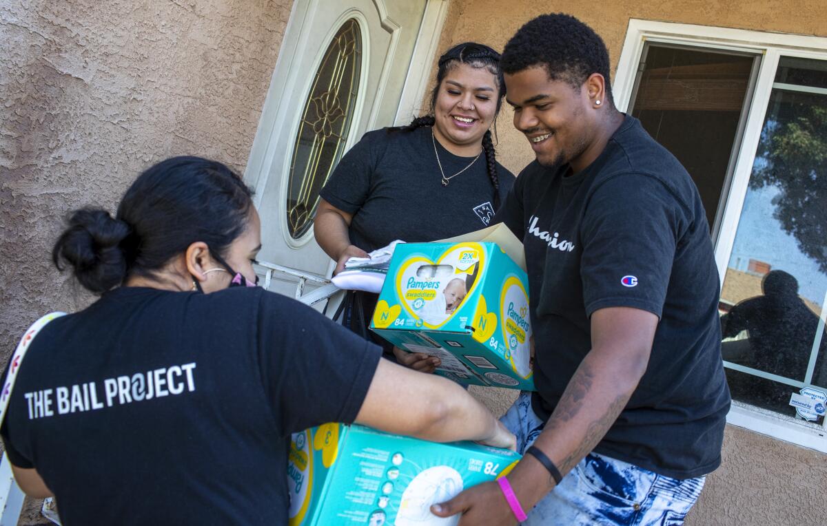 Priscilia Martinez, left, of the Compton chapter of the Bail Project delivers supplies to Tomajae Tolliver.