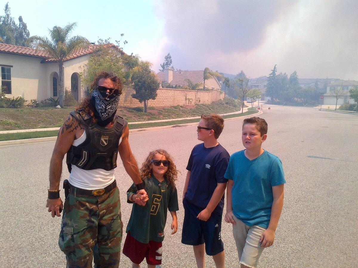 Greg Dawson and his three children with the Spring fire burning in the background.