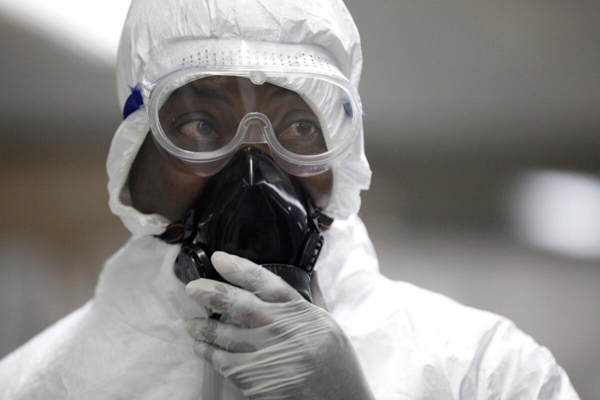 A Nigerian health official wearing a protective suit waits at the international airport in Lagos to screen passengers for the Ebola virus in August.