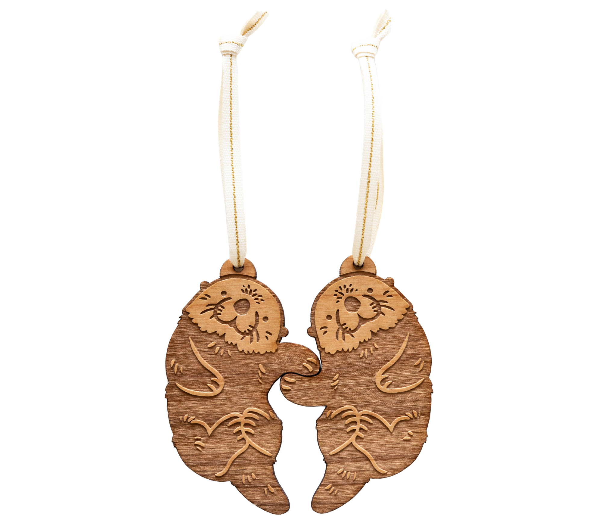A pair of handmade wood ornaments from Hereafter feature two otters holding hands 