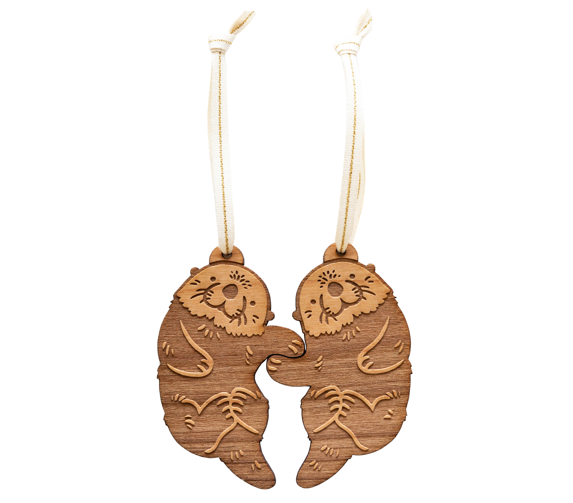 A pair of handmade wood ornaments from Hereafter feature two otters holding hands