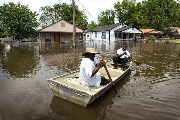 Darrell Evans, left, and Jermaine Jarrett paddle down a flooded street in their Memphis, Tenn., neighborhood.