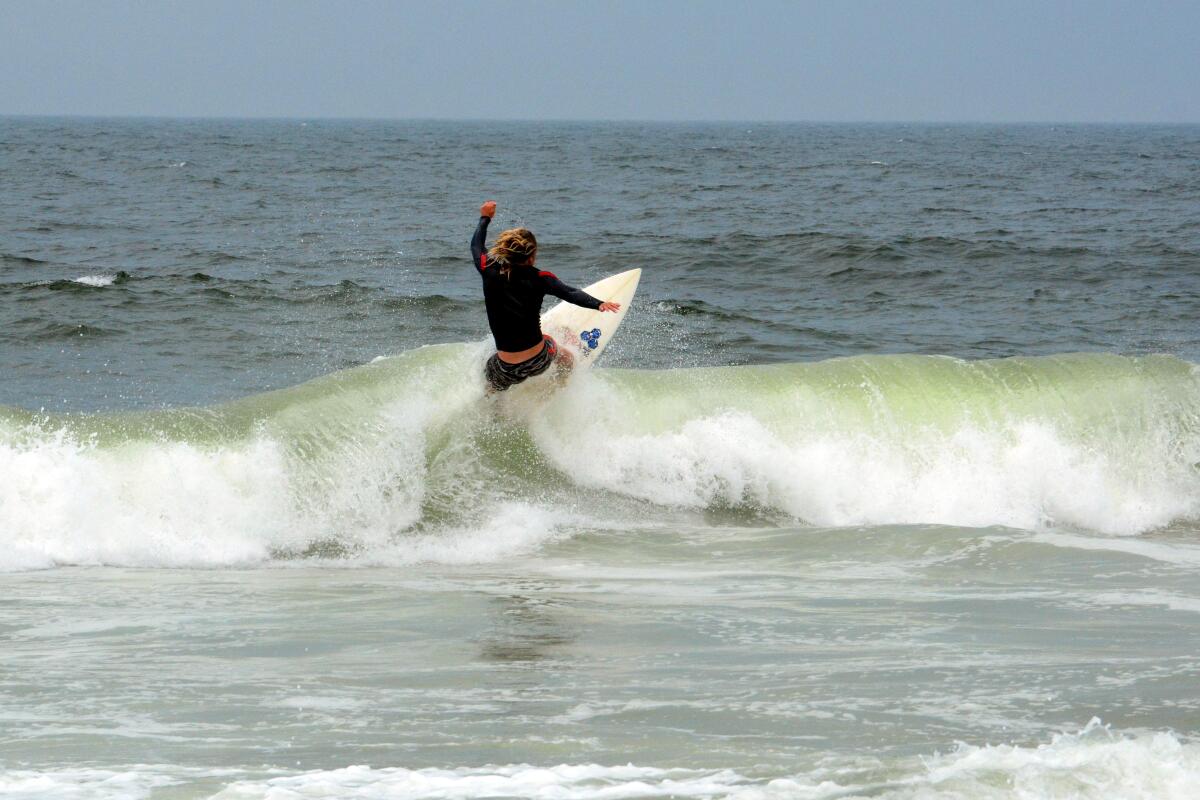 A surfer rides a wave near Casino Pier.