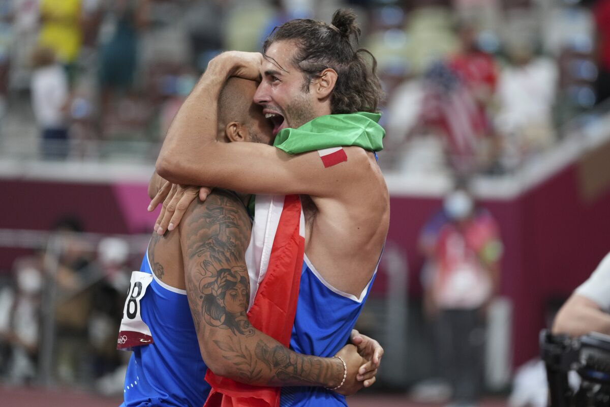 High jump gold medalist Gianmarco Tamberi, right, of Italy, congratulates compatriot Lamont Marcell Jacobs, after he won the final of the men's 100-meters at the 2020 Summer Olympics, Sunday, Aug. 1, 2021, in Tokyo. (AP Photo/Matthias Schrader)