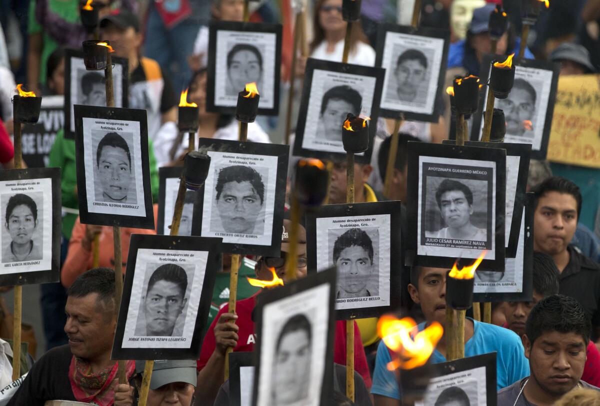 ARCHIVO - Familiares de los 43 estudiantes desaparecidos en el sur de México muestran fotos.