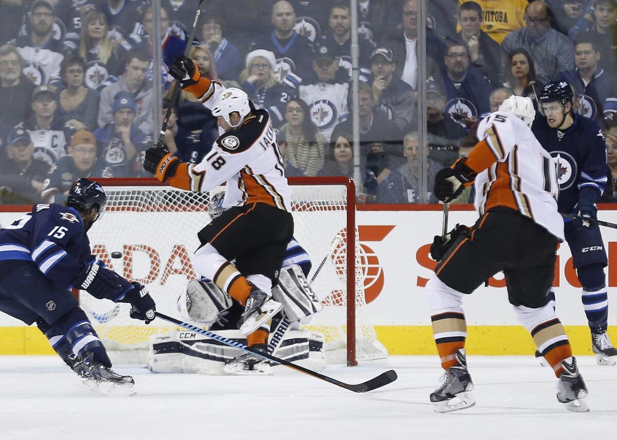 Ducks' Ryan Getzlaf, right, scores as teammate Tim Jackman jumps in front of Winnipeg goaltender Michael Hutchinson as Jets' Matt Halischuk defends during the second period of the Ducks' 4-1 win on Saturday.