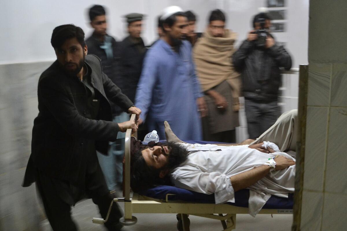 A person injured in a bomb blast waits for treatment Thursday at a local hospital in Peshawar, Pakistan.