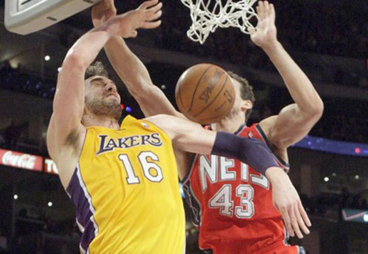 Lakers center Pau Gasol scores over New Jersey's Kris Humphries during the first half of the Lakers' 91-87 victory Tuesday at Staples Center.