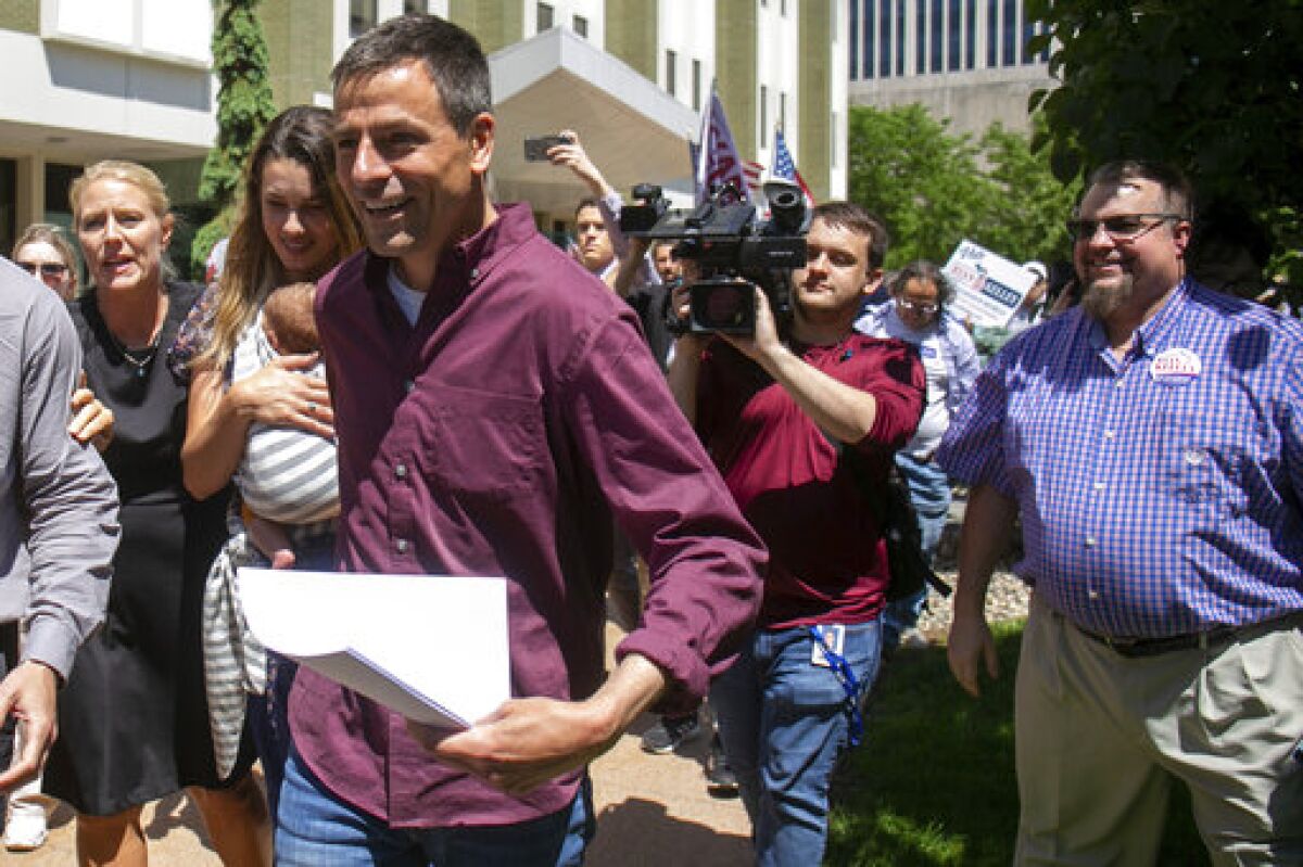 Michigan gubernatorial candidate Ryan Kelly leaves the U.S. District Court in Grand Rapids, Mich., with his family and supporters on Thursday, June 9, 2022. Kelley has been charged with four misdemeanors from his involvement with the riot at the Capitol Building in Washington on Jan. 6, 2021. (Daniel Shular/The Grand Rapids Press via AP)