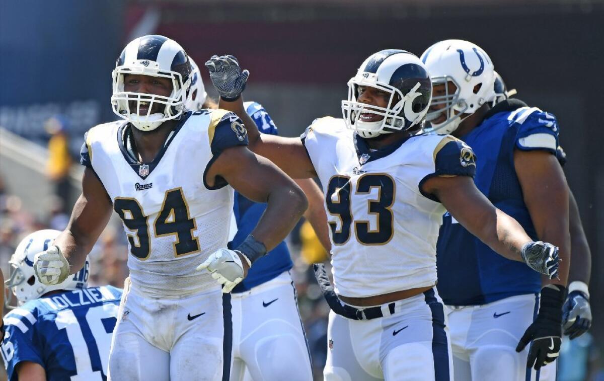 Rams defensive ends Robert Quinn (94) celebrates his sack with Ethan Westbrooks (93) during a game against the Colts at the Coliseum on Sept. 10.