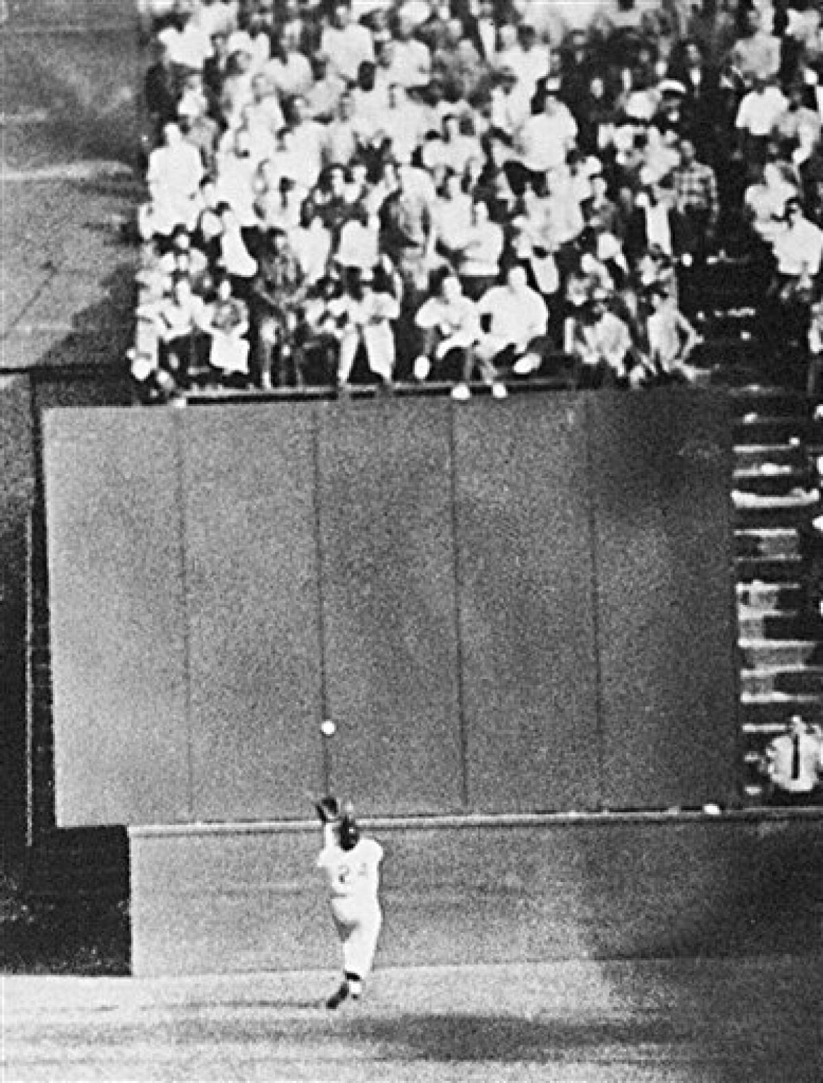 FILE- In this Sept. 29, 1954 file photo, New York Giants center fielder Willie Mays, running at top speed with his back to the plate, gets under a 450-foot blast off the bat of Cleveland Indians first baseman Vic Wertz to pull the ball down in front of the bleachers wall in the eighth inning of Game 1 of the World Series at the Polo Grounds in New York. In making the miraculous catch with two runners on base, Mays came within a step of crashing into the wall. The Giants won 5-2.
