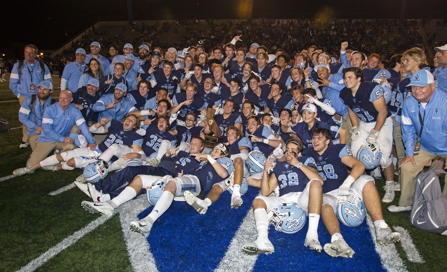 The Corona del Mar football team celebrates after defeating Serra 35-27 in the CIF State Division 1-A title game at Cerritos College on Saturday.