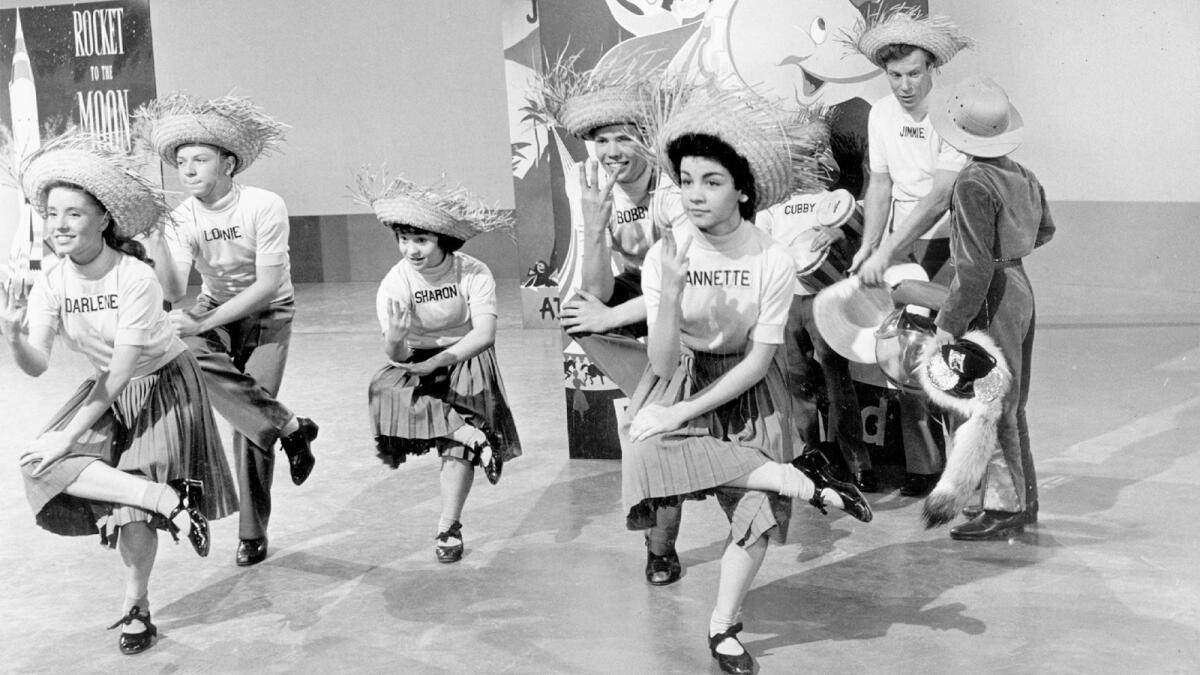 Mouseketeers Darlene Gillespie, left, Lonnie Burr, Sharon Baird, Bobby Burgess, Annette Funicello, Cubby O'Brien and leader Jimmie Dodd practice the calypso.