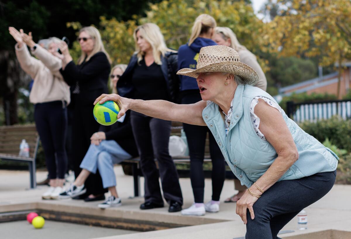 A woman throwing a bocce ball.