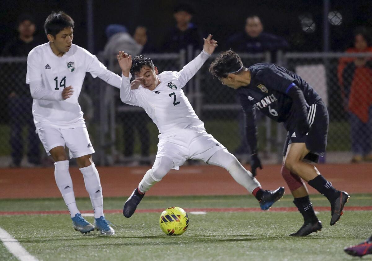 Costa Mesa's Roman Serpas (2) is knocked down by Estancia's Esteban Esquivel (6) as they meet at the ball on Wednesday.